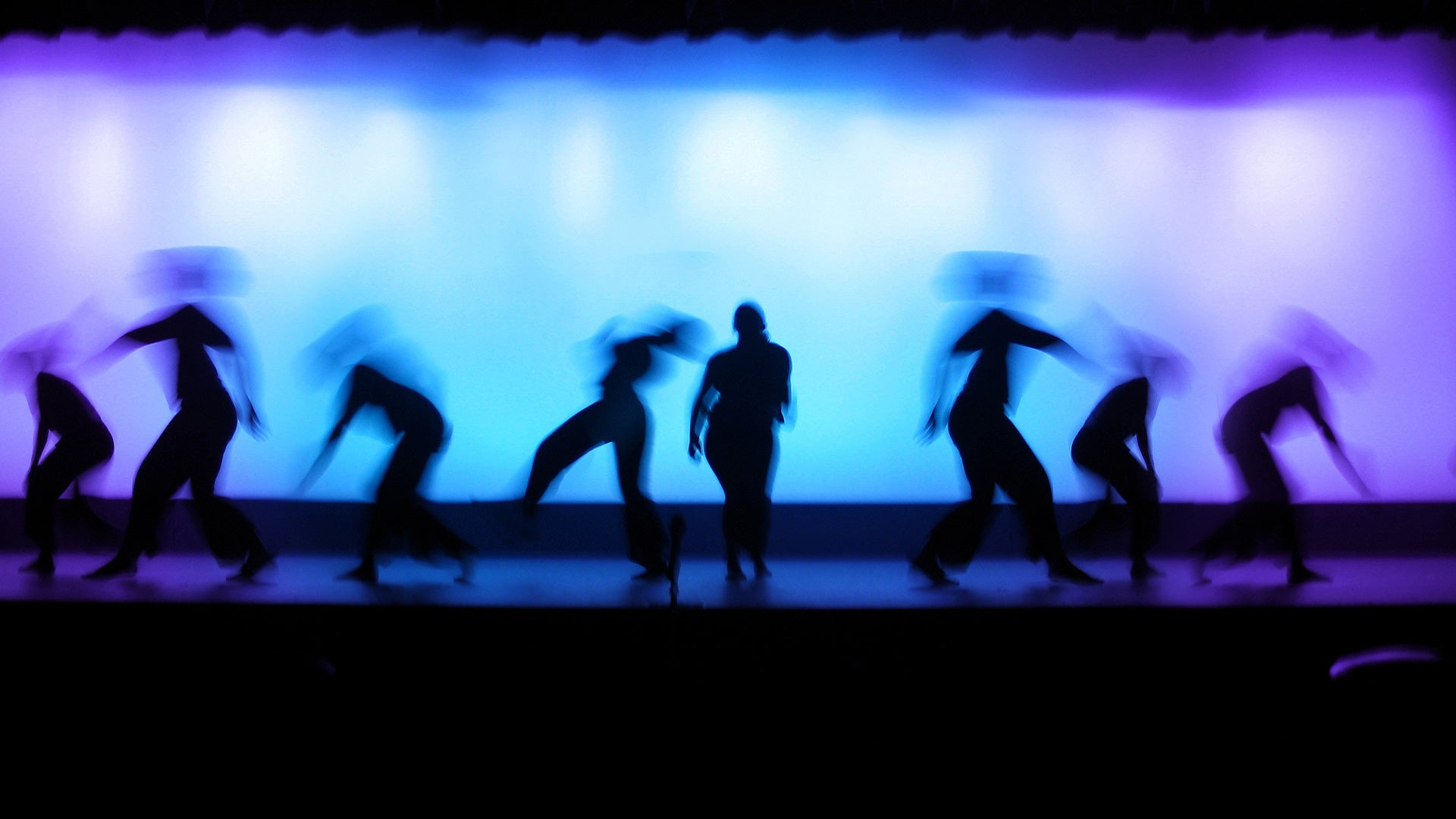 Silhouettes of students on a theatre stage