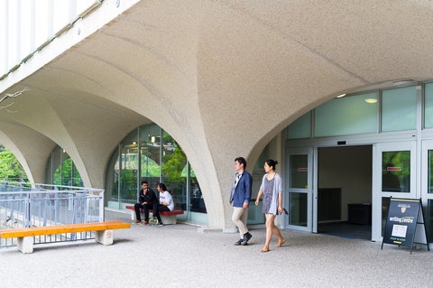 two people walking out of the Dana Porter library