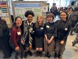 Group of students standing in front of poster board