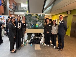 Group of students standing in front of their project poster.