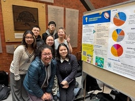 Group of students standing in front of their project poster.
