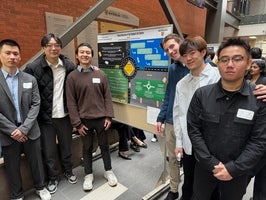 Group of students standing in front of their project poster.