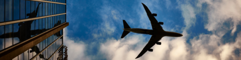 An airplane flying next to a building