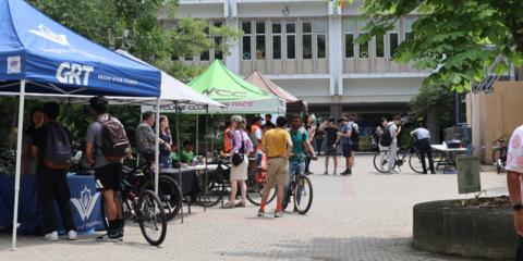 People with bikes talking at different booths at Bike Fair.