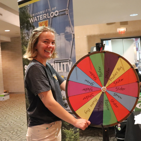 Alyssa Ford with spinning wheel at Sustainability Office booth during BioBlitz community fair