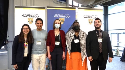 Students posing in front of UWaterloo banners