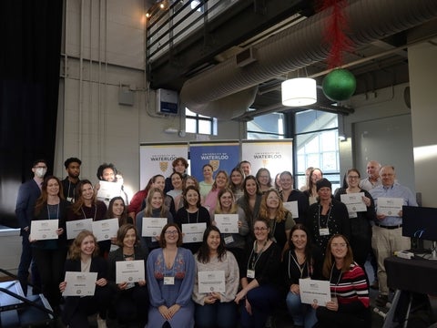 Employees holding up their certificates. 