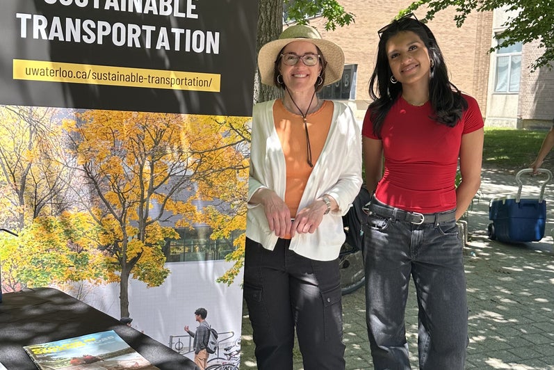 Tara and student standing in front of sustainable transportation banner
