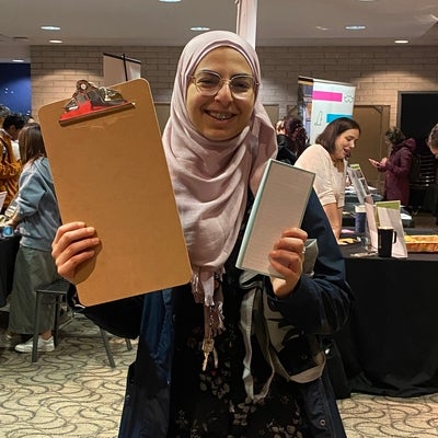 Student holding up a clipboard and notepad