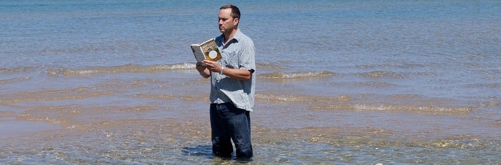 Professor McMurry reading a book in the water