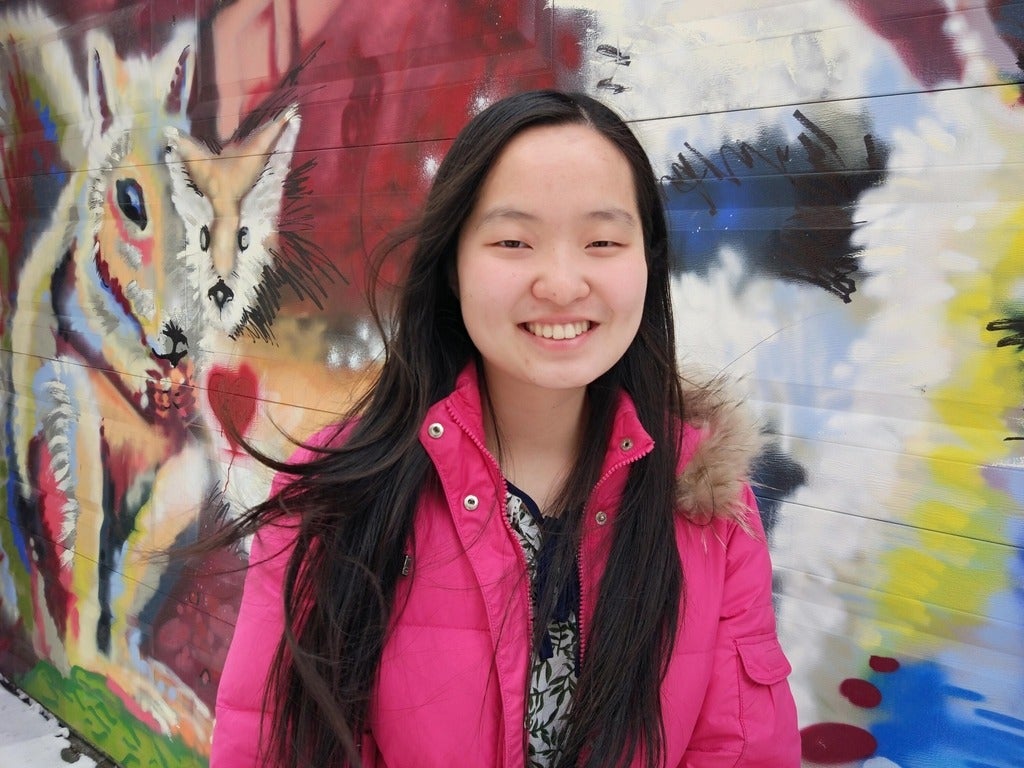 Maggie Chang standing in front of wall mural