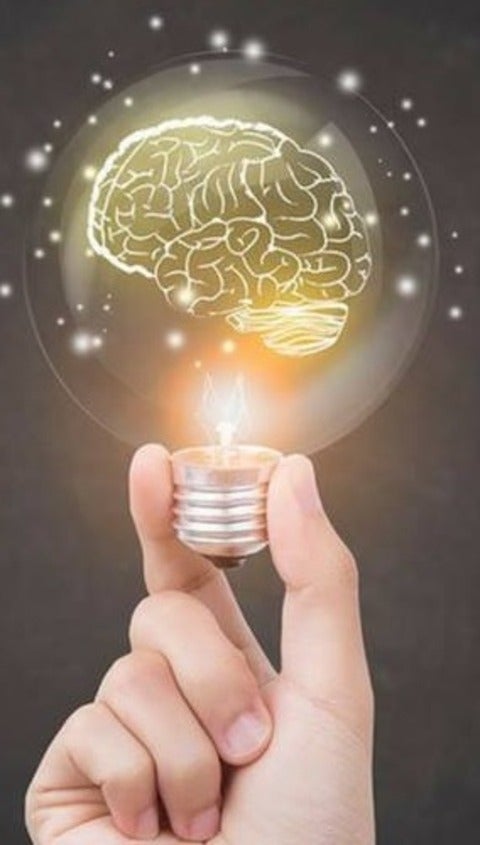 Hand holding a light bulb with glowing brain inside