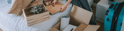 A person packing belongings into a box