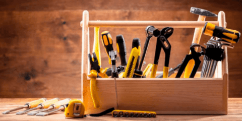 Wooden box of tools in front of wooden wall