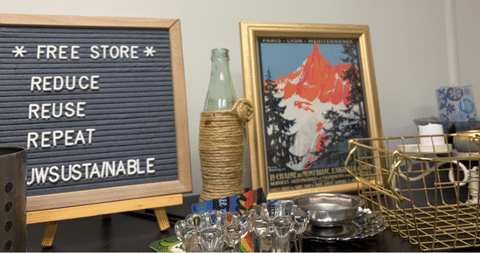 Free store sign that says reduce, reuse, repeat with items on display