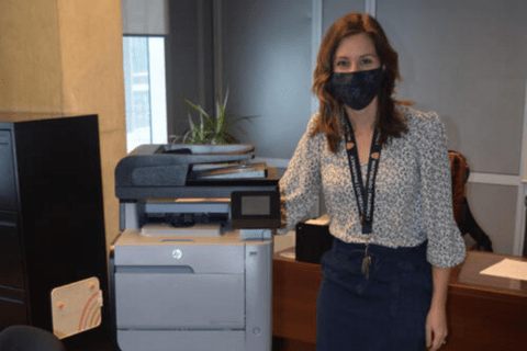 Kaitlin Bykoski wearing a mask next to her printer