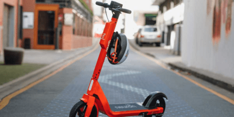 Orange Neuron e-scooter on road