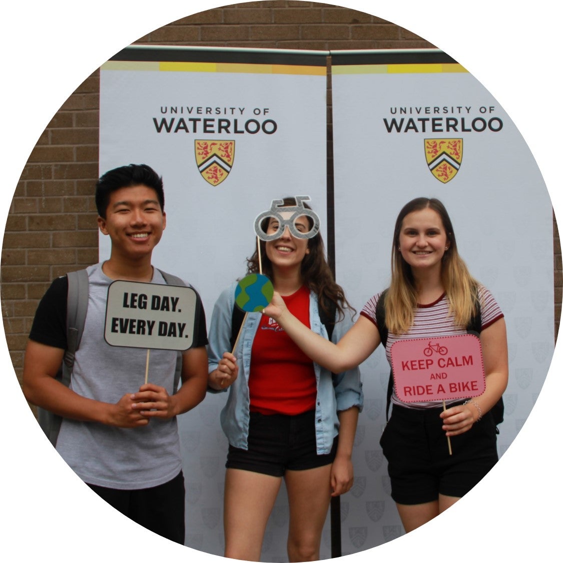 Three students posing with photobooth props at Bike Lunch 2018