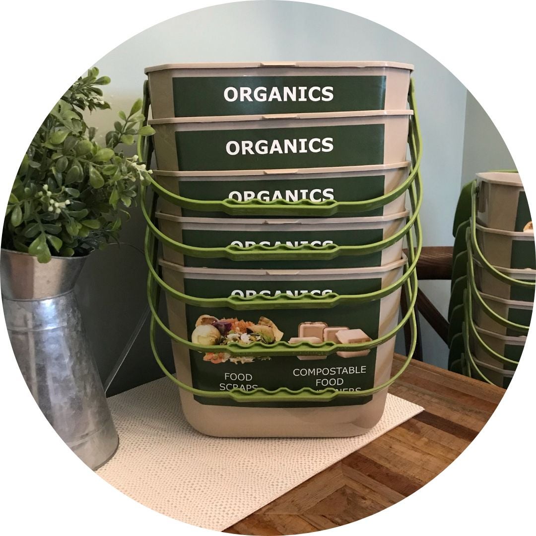 Countertop organics bins on table with greenery