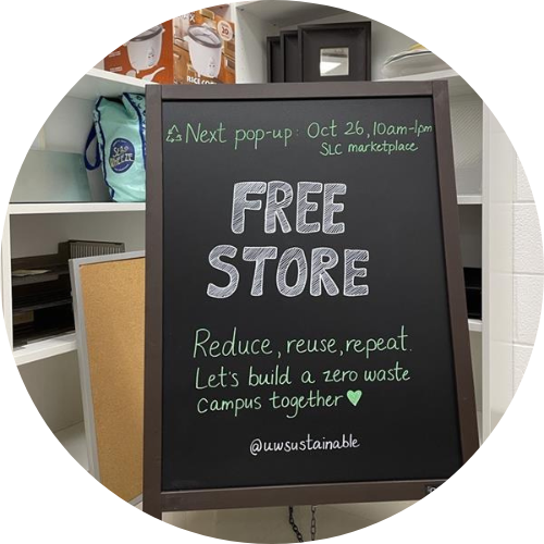 Free Store chalkboard sign in front of white shelves with inventory