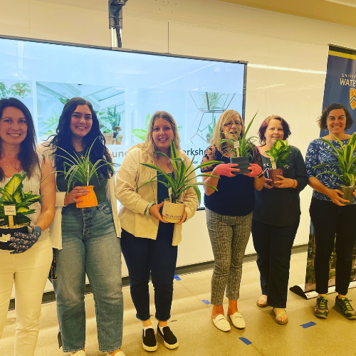 Office members holding potted plants