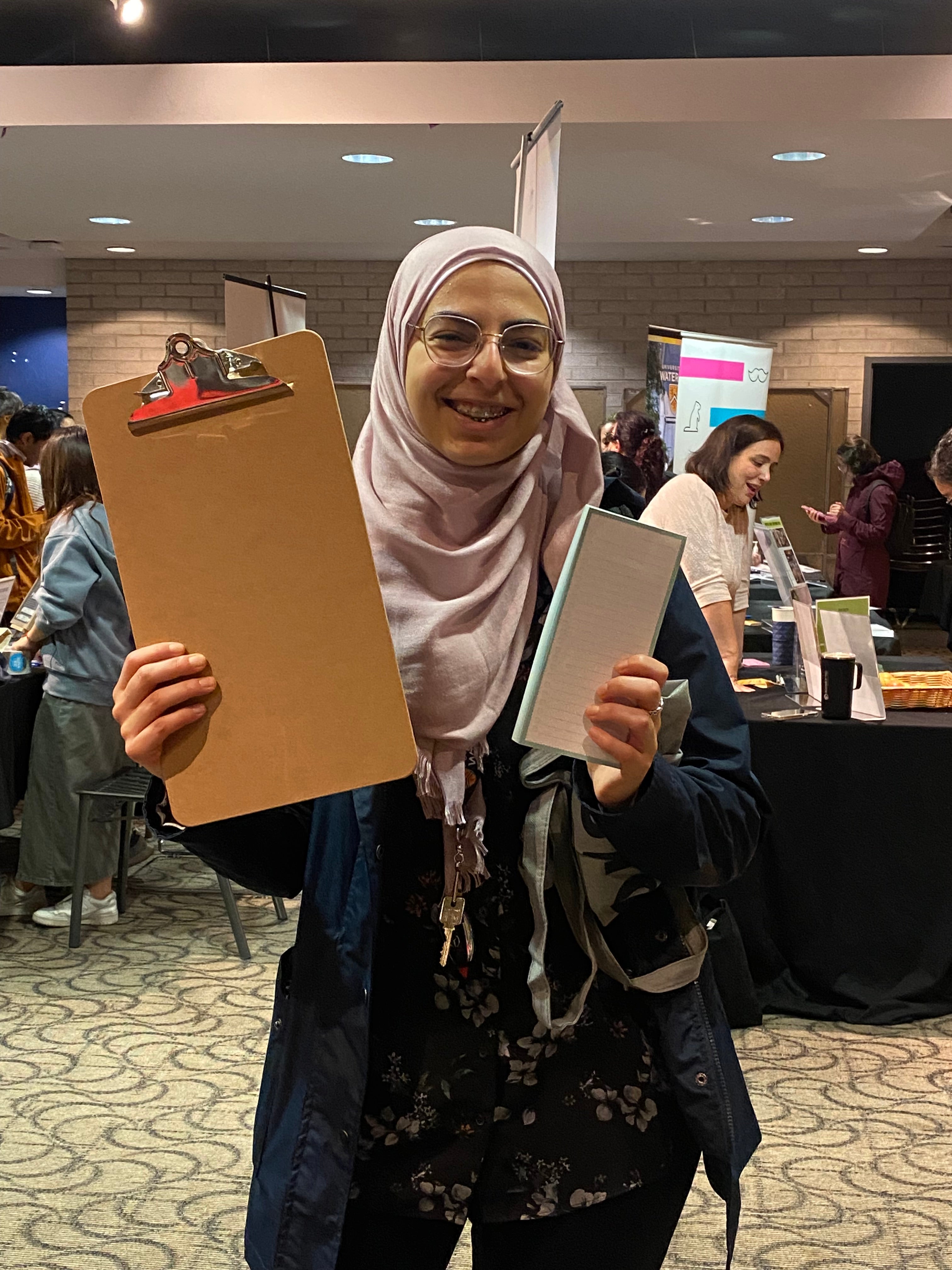 Student holding up a clipboard and notepad