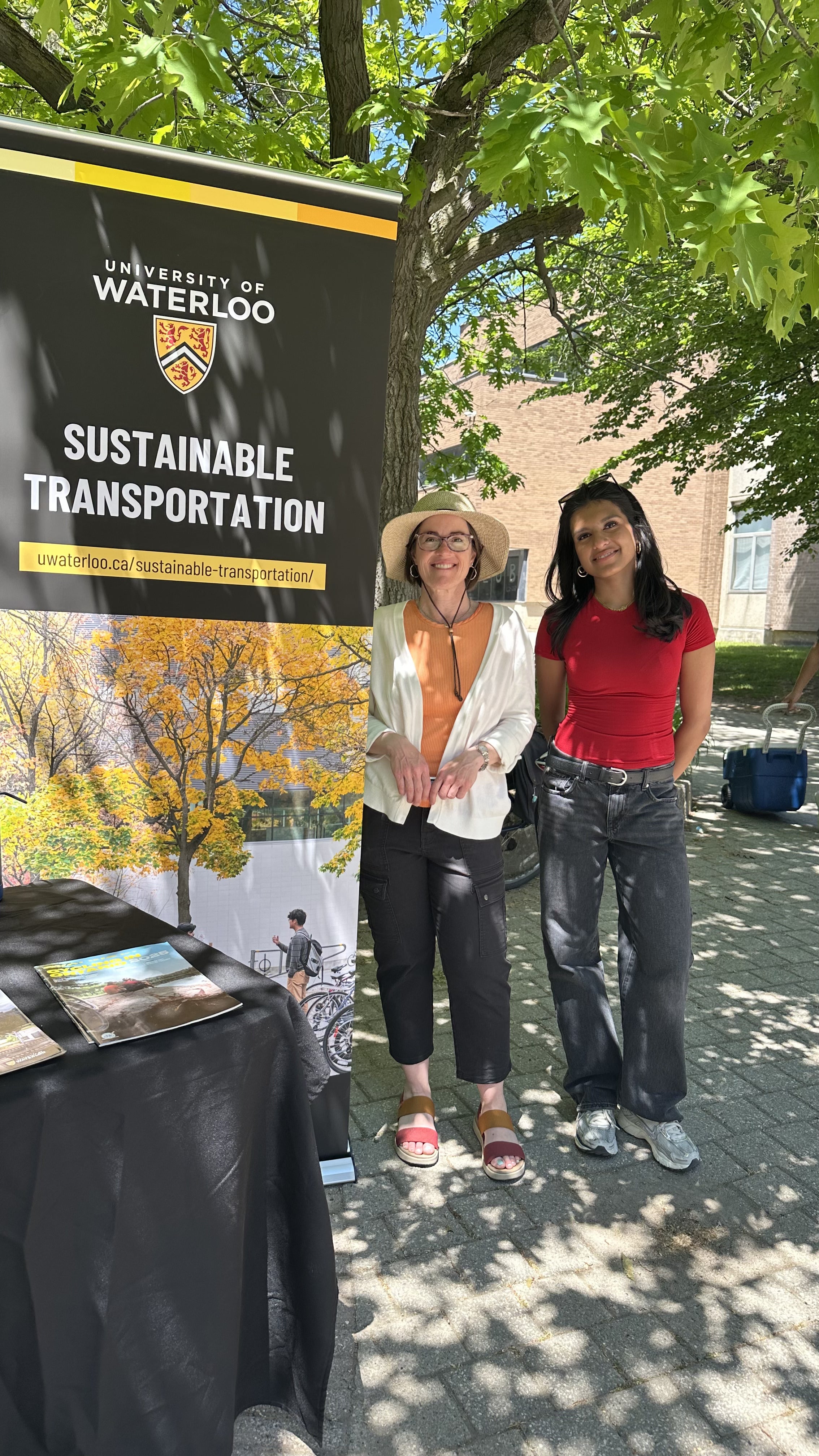 Tara and student standing in front of sustainable transportation banner