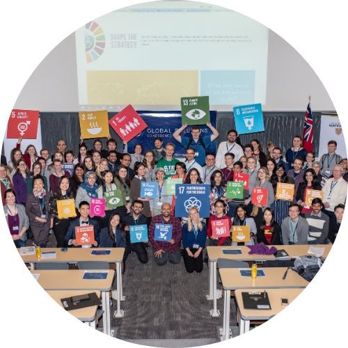 Attendees from Global Solutions conference holding up SDGs