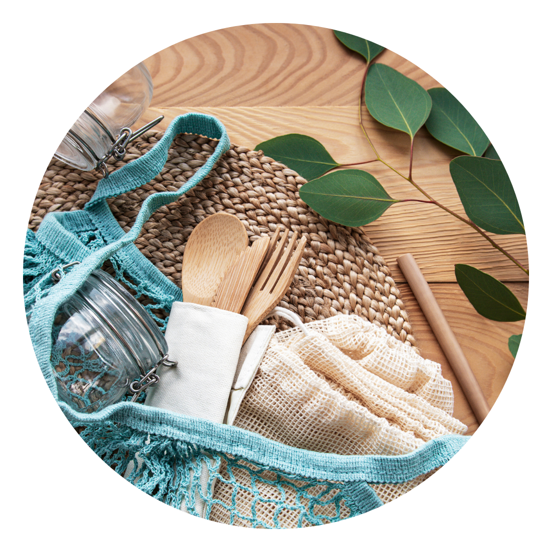 Reusable cloth bag with jar and reusable cutlery on a wood table with greenery