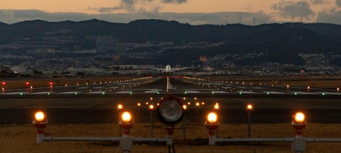 Plane taking flight from runway at sunrise