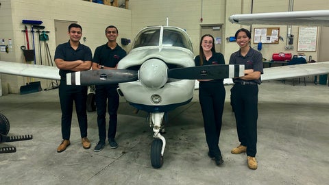 Group photo of students with plane