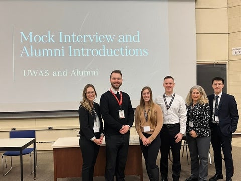 A group of people standing at the front of a classroom.