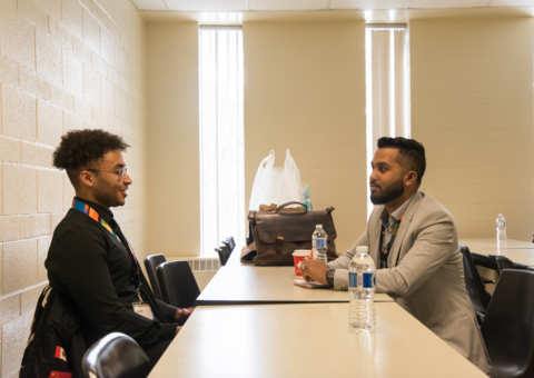 Two people sitting at a desk face-to-face