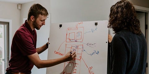 Researchers collaborating with a whiteboard