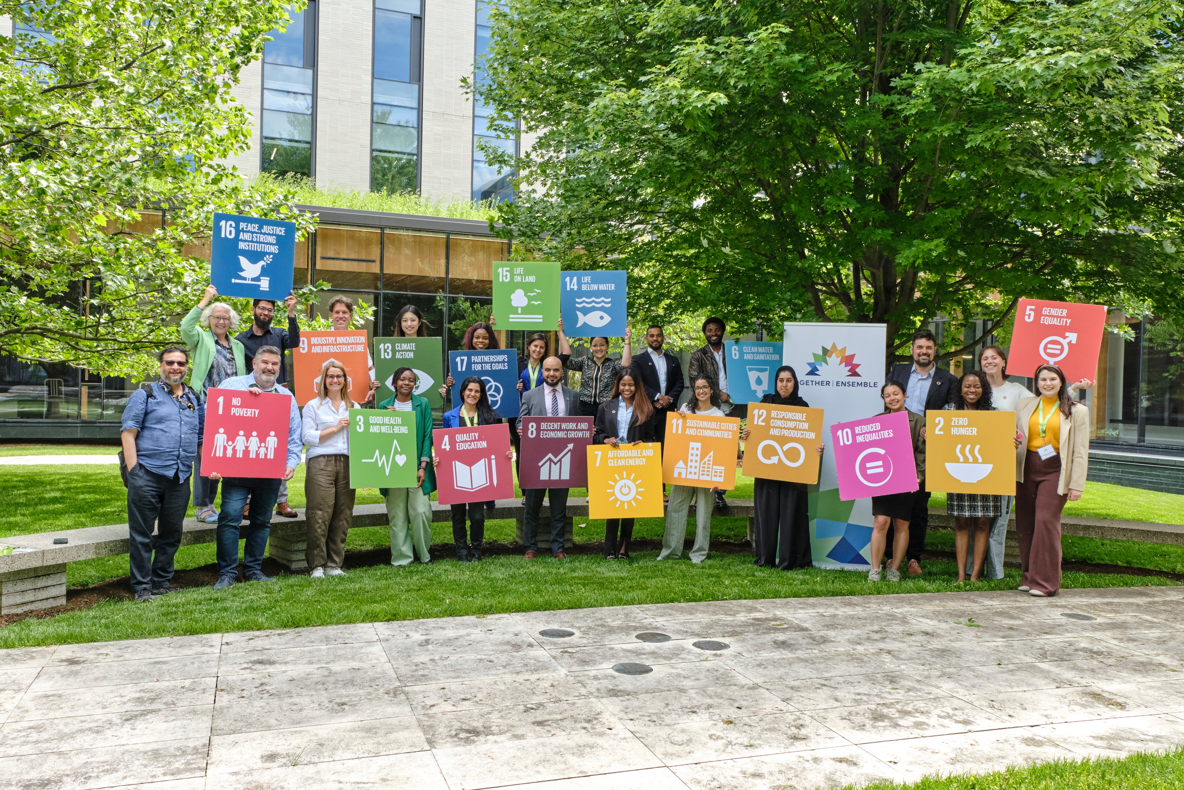 conference organizers holding colourful SDG cards outdoors