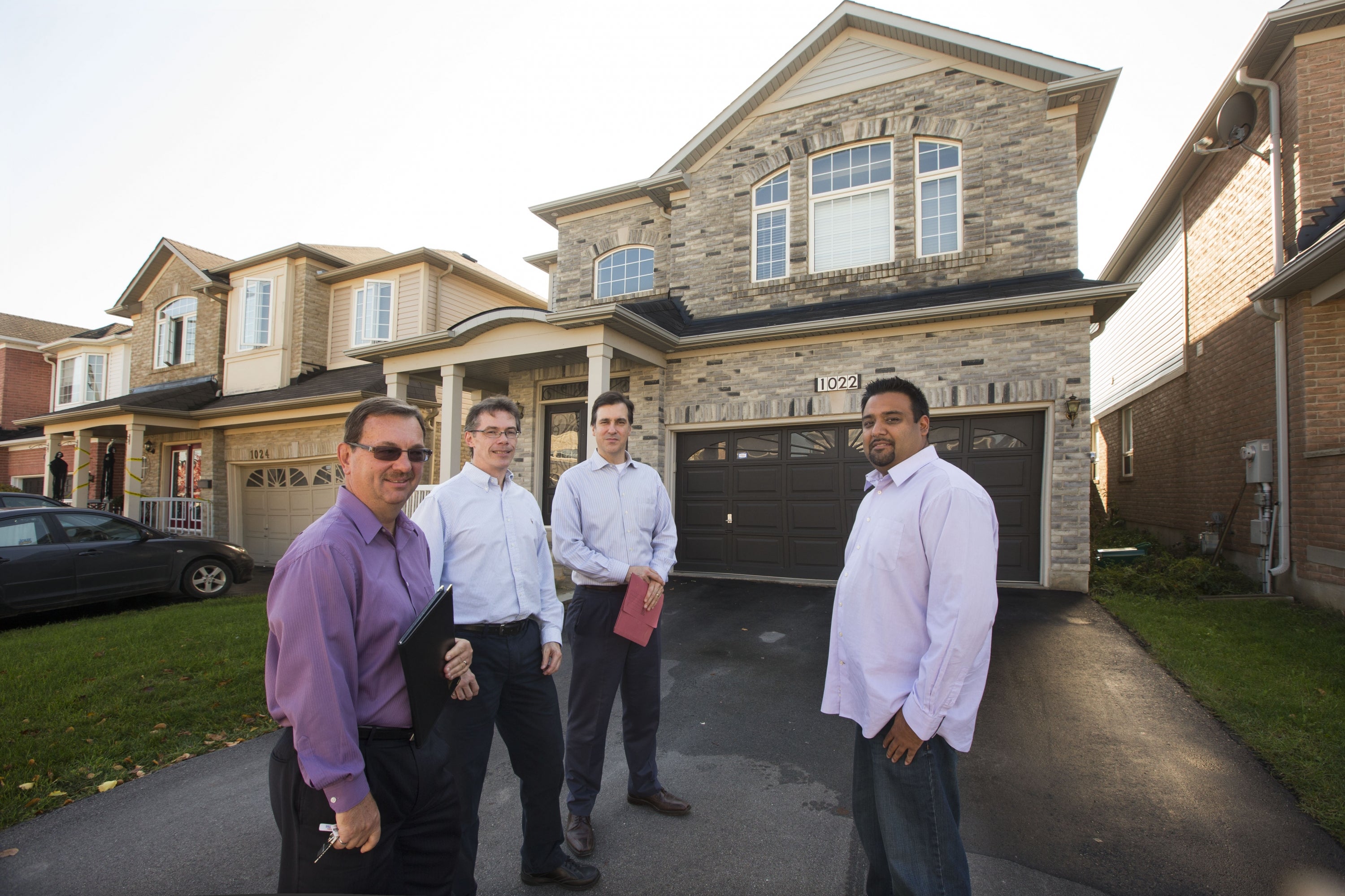 Frank Lasowksi, Gord Ellis, Ian Rowlands, and Deep Mehta in front of a house.