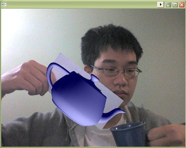 student holding a piece of paper with an 3D teapot projected onto it