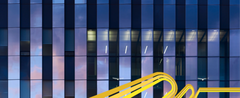 Photo of the University of Waterloo's engineering building with pink and blue clouds poking through the window panes.