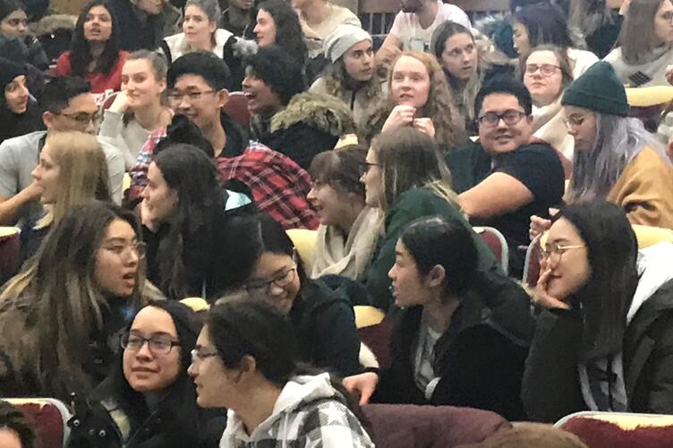 Students sitting close to one another, facing forwards