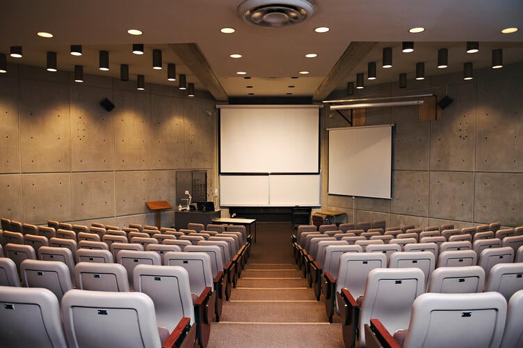 Dimly lit room with no windows and lecture seating