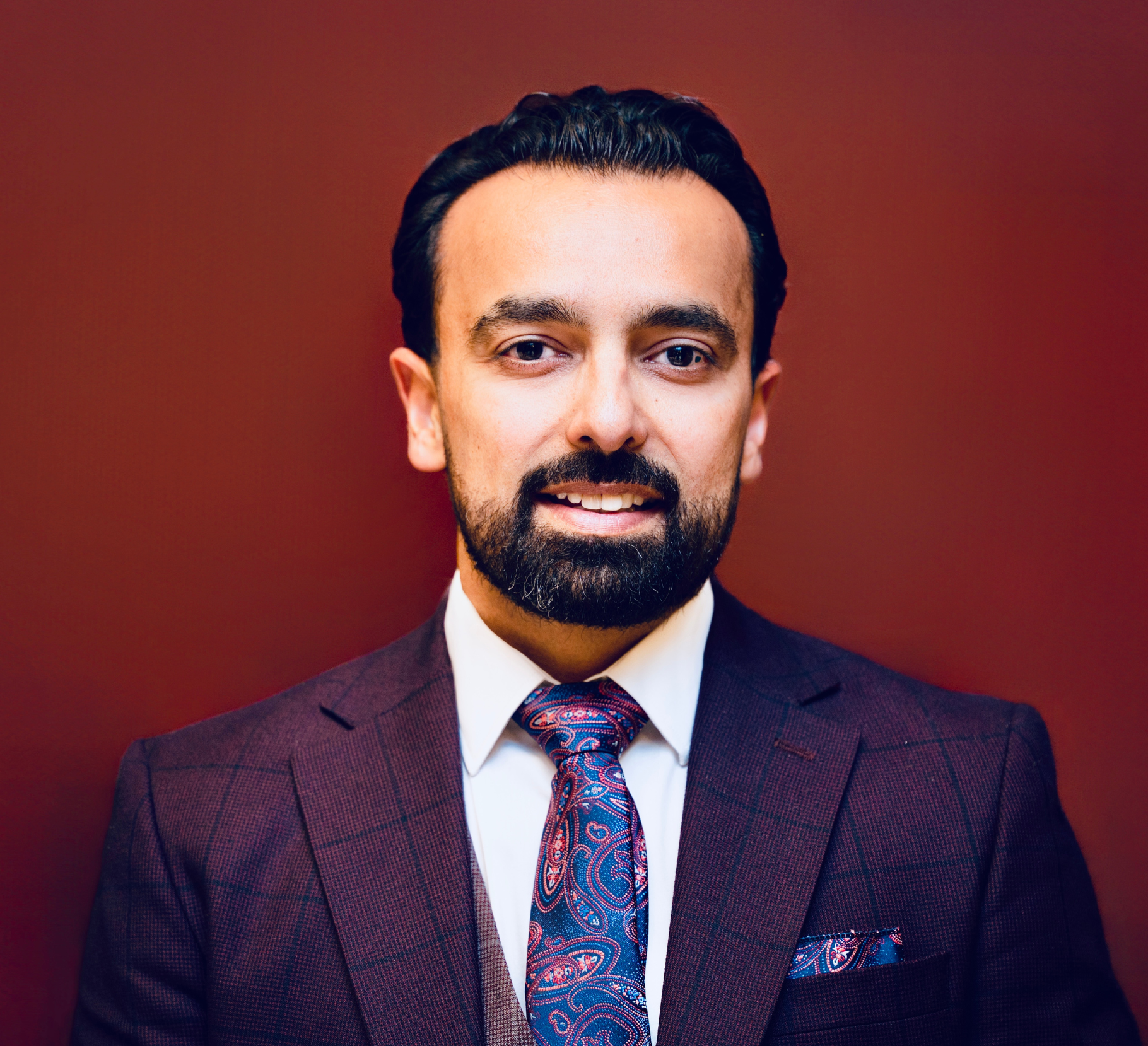 A professional headshot of Bilal Khan