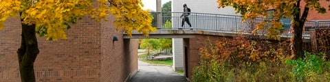 Student walking across overpass at Burt Matthews Hall