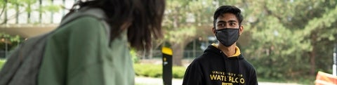 Student wearing a face mask outside of Dana Porter library