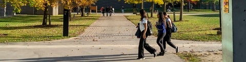 Three students walking along a path outside of Math and Computers