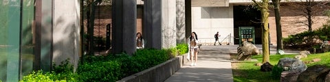 Student on cell phone walking past the Quantum Nano Centre