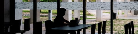 Silhouette of a student working on a computer in the Student Life Centre