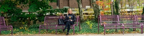 Student sitting on bench with Waterloo sweater