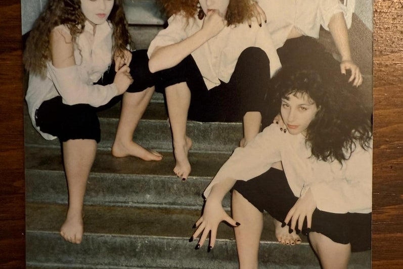 four women sitting together on stairs