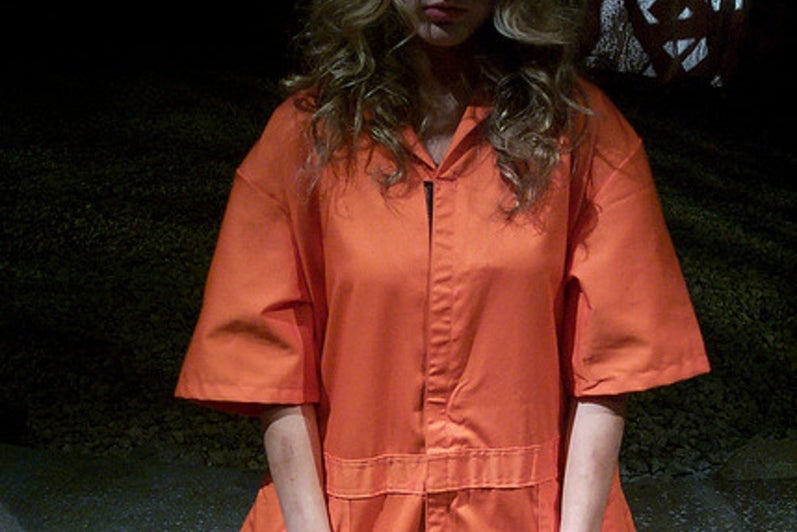 Girl standing in handcuffs looking distraught