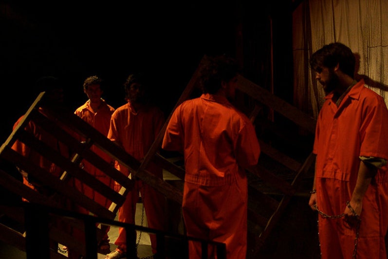 Group of men standing in prison uniforms